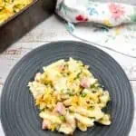 Ham and cheese pasta casserole on a plate next to a pan.