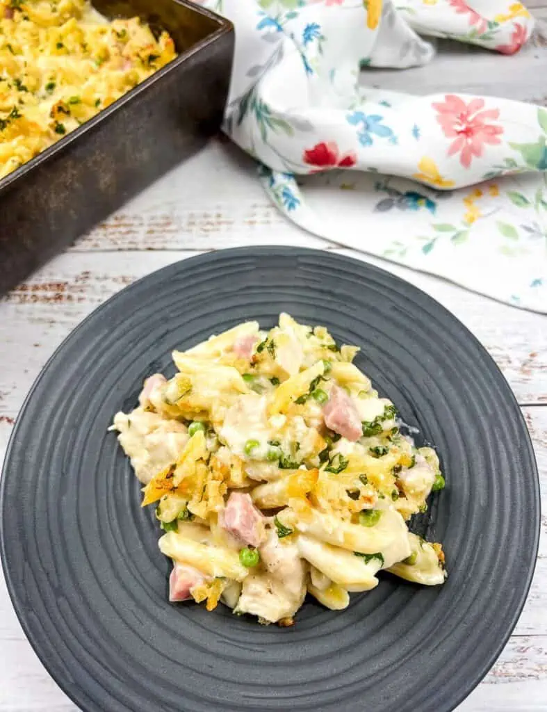 Ham and cheese pasta casserole on a plate next to a pan.