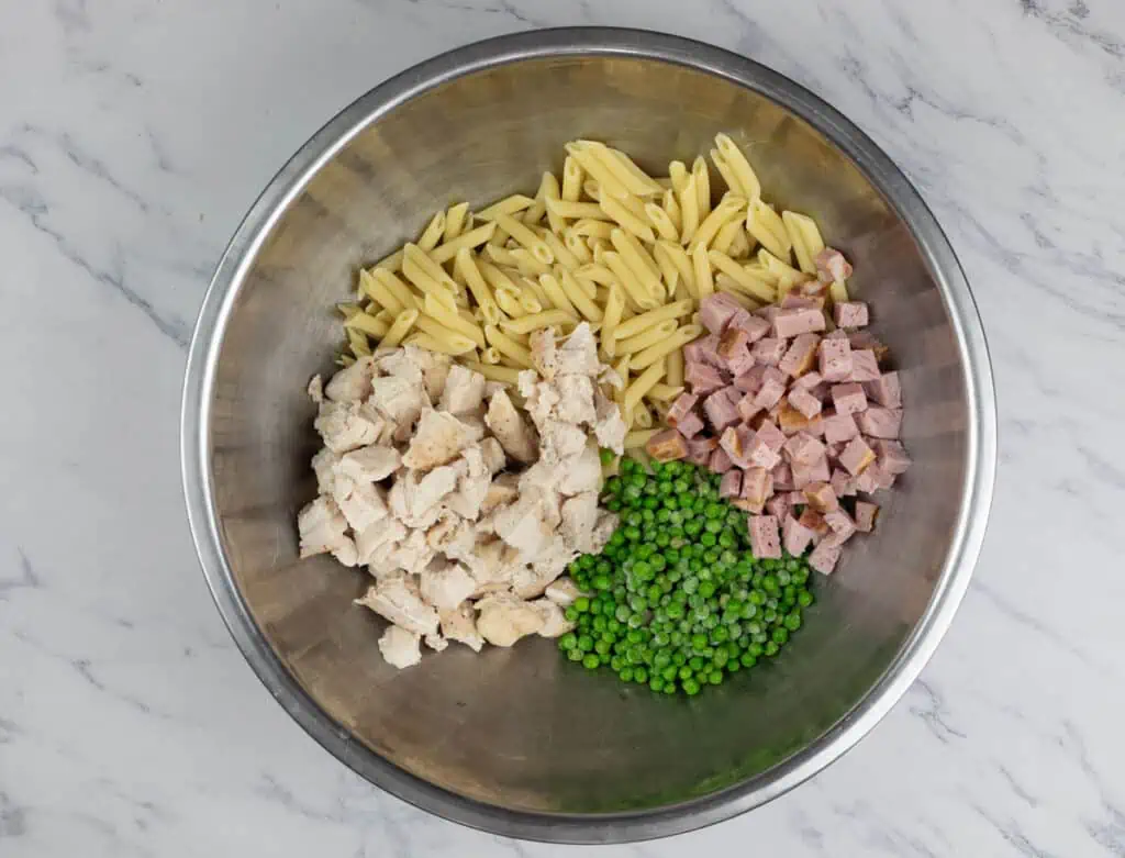 Ham, peas and pasta in a bowl.