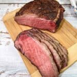 Sliced Smoked New York Strip Roast on a cutting board.