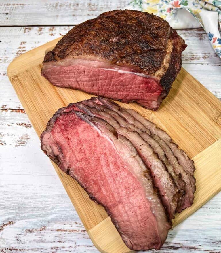 Sliced Smoked New York Strip Roast on a cutting board.
