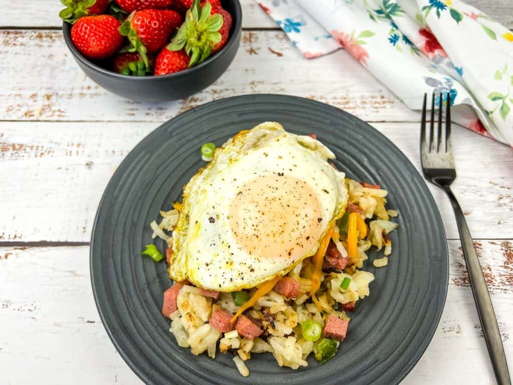 A plate of Montreal Smoked Meat Hash with an egg on top.