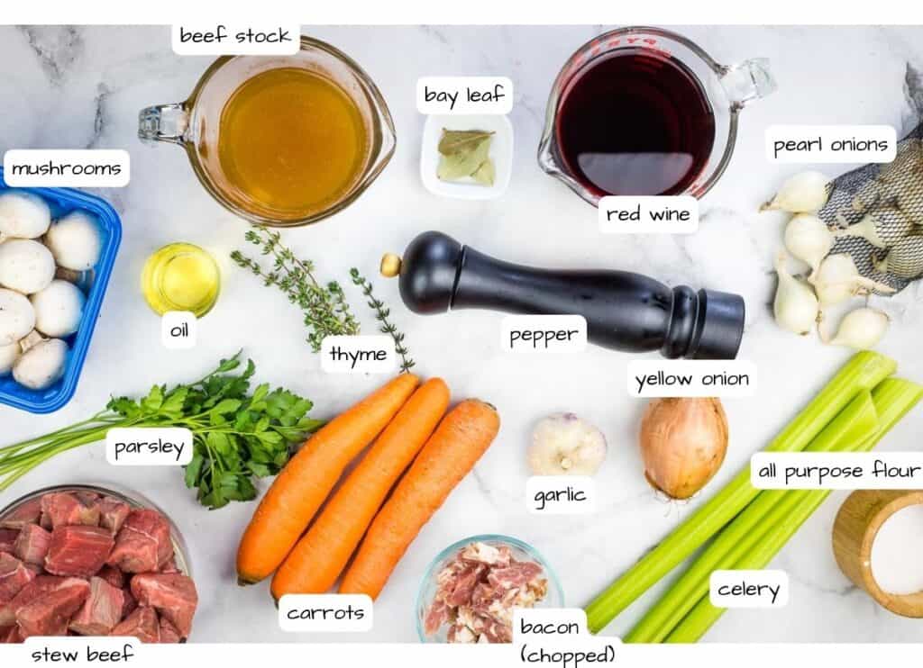 Ingredients for beef bourguignon on a marble countertop.
