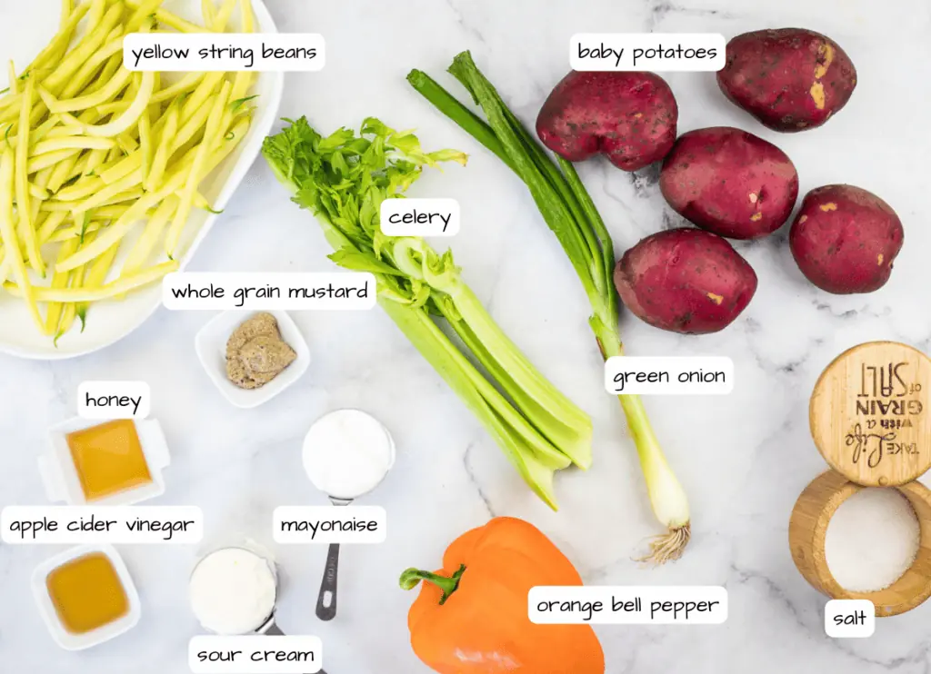 The ingredients for a zucchini soup are laid out on a marble table.