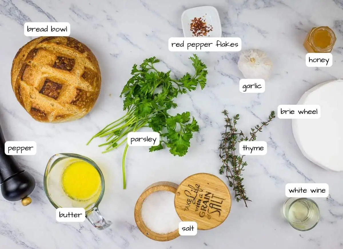 The ingredients of a bread with herbs and spices on a marble table.