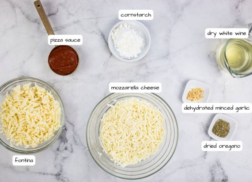 The ingredients for a pasta dish are shown on a marble table.