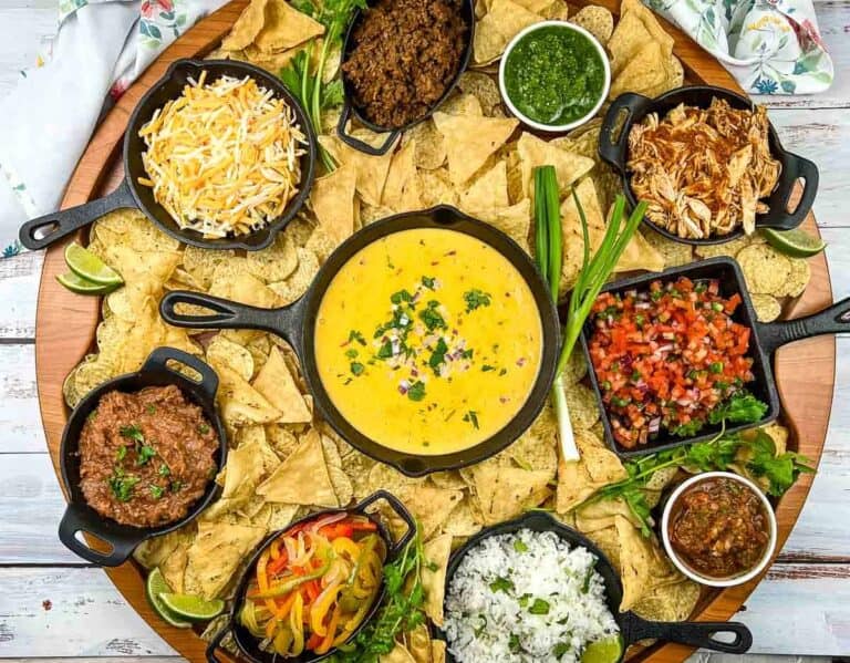 A mexican dip platter with tortilla chips, salsa, and guacamole.