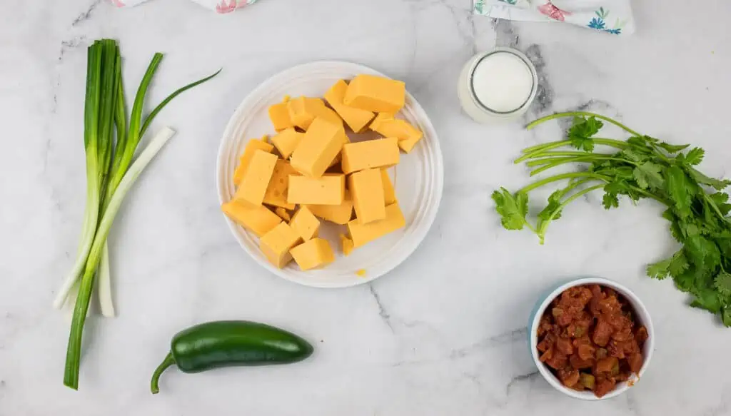 Ingredients for mexican cheese enchiladas on a marble table.