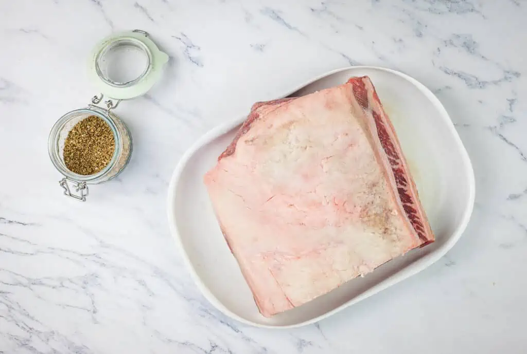 A piece of meat is sitting on a white plate.