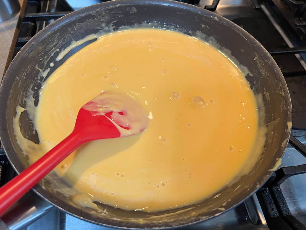 A frying pan with a red spatula.