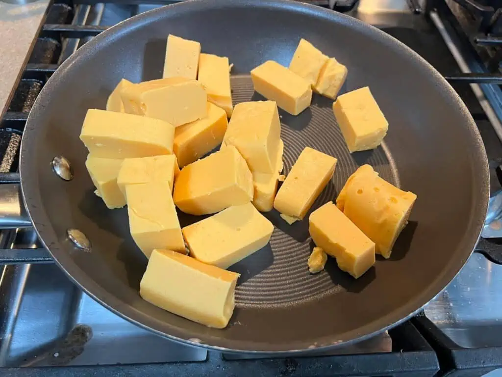 Cubes of cheese in a frying pan.