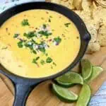 Mexican cheese dip in a cast iron skillet with tortilla chips.