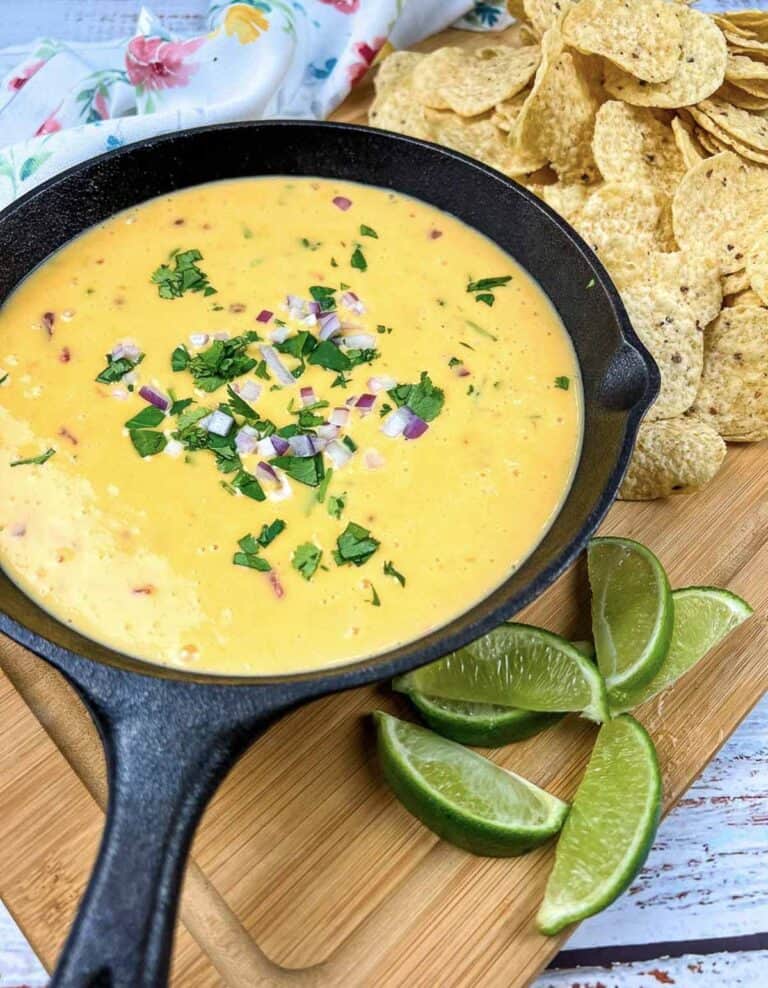 Mexican cheese dip in a cast iron skillet with tortilla chips.