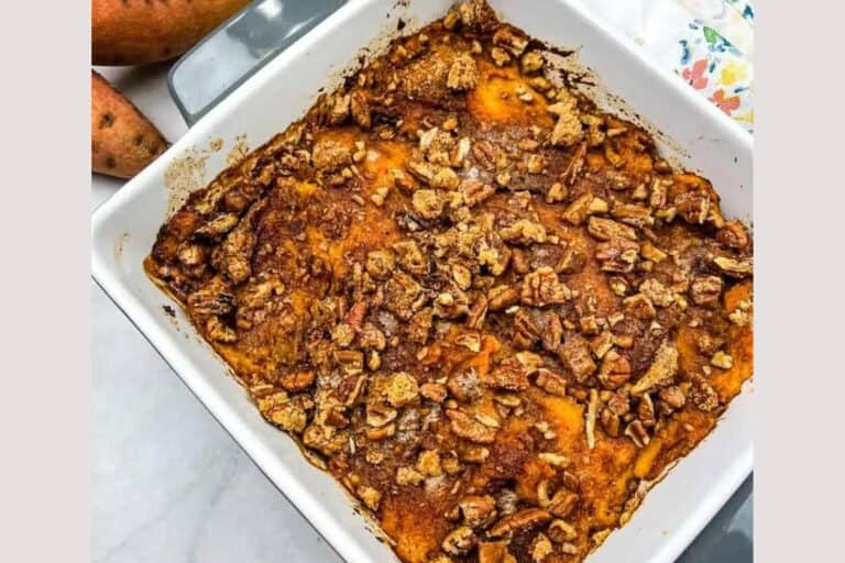 Sweet potato casserole with pecans in a white dish.