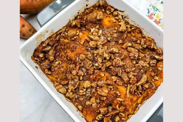 Sweet potato casserole with pecans in a white dish.