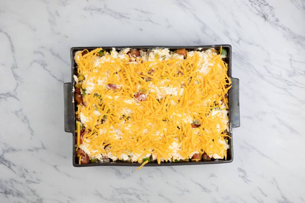 A casserole dish with cheese and bacon on top.
