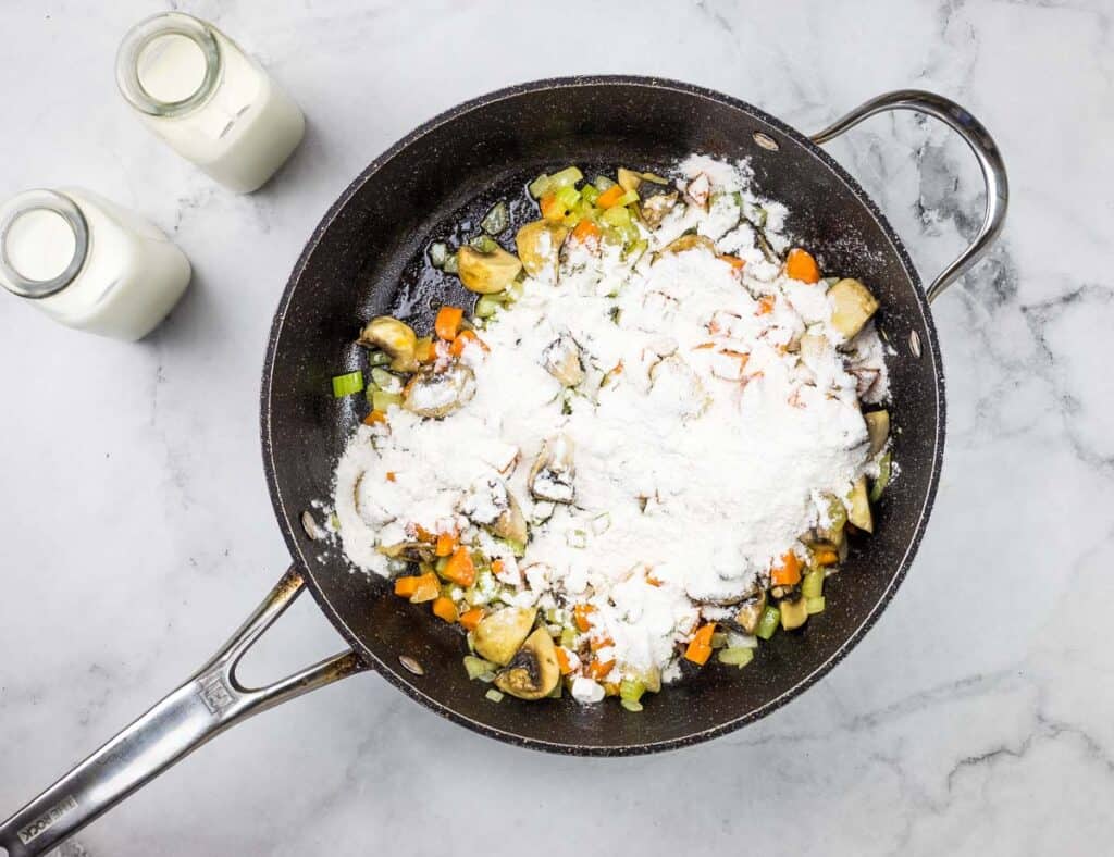 A frying pan filled with vegetables and flour.