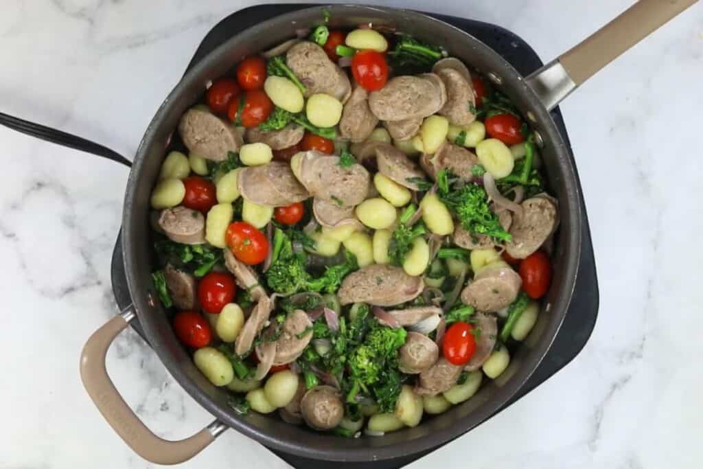 A pan full of vegetables and meat in a skillet.