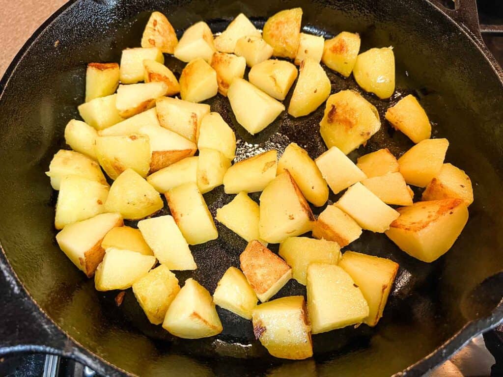 Sliced potatoes in a cast iron skillet.