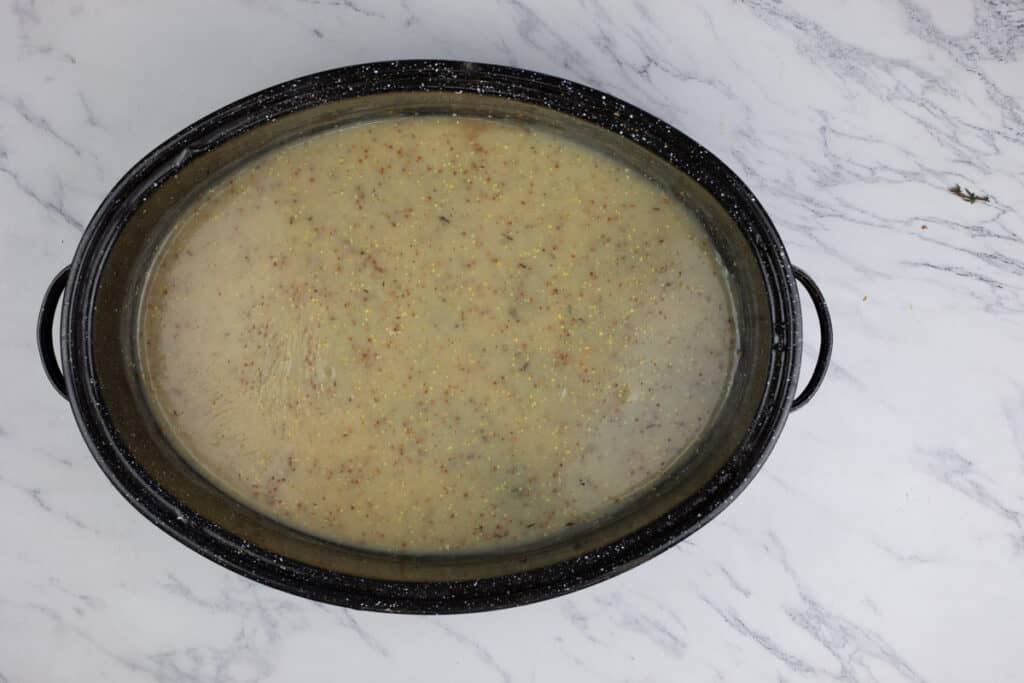 A pot of soup on a marble countertop.