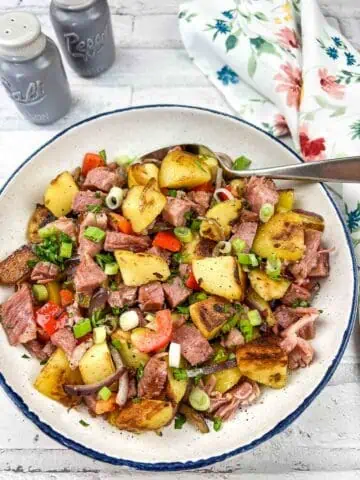 A bowl of Leftover Cottage Roll Hash on a table.