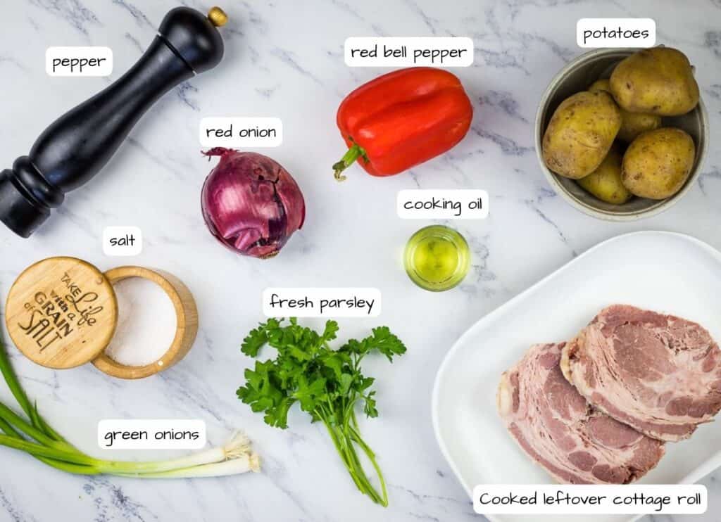 Ingredients for a roast pork recipe on a marble table.