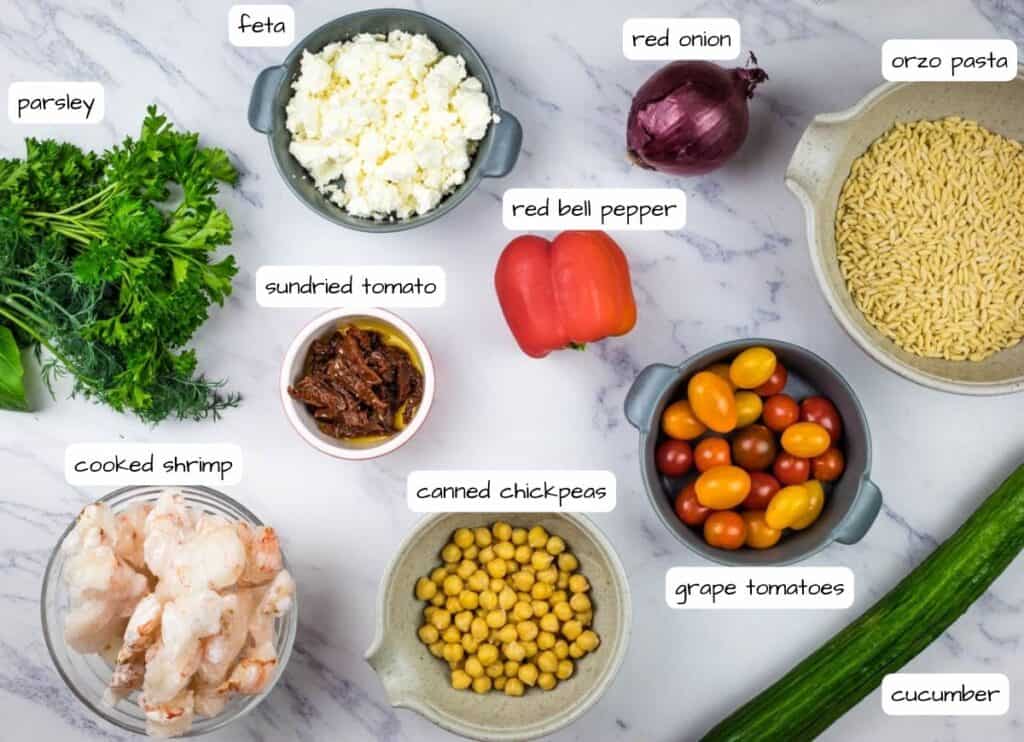 The ingredients for a quinoa salad are laid out on a marble table.