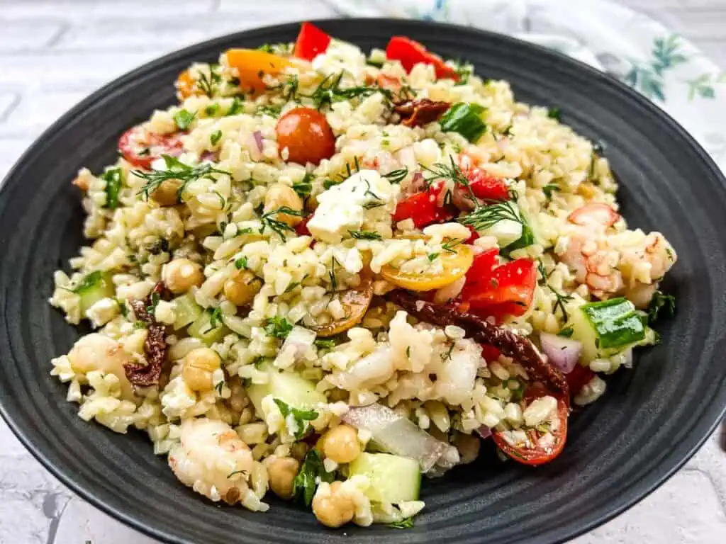 A bowl of Mediterranean Orzo Salad with shrimp, tomatoes and chickpeas.