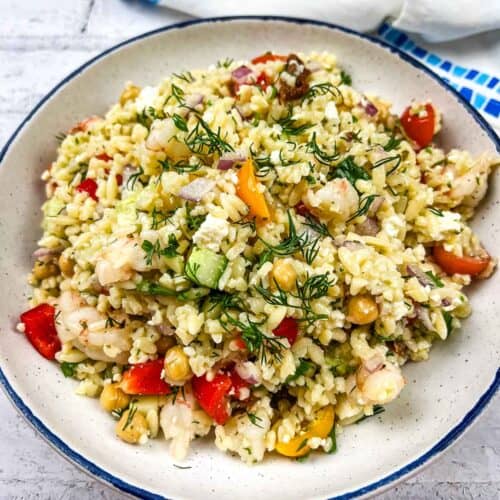A plate of Mediterranean Orzo Salad with shrimp and vegetables.