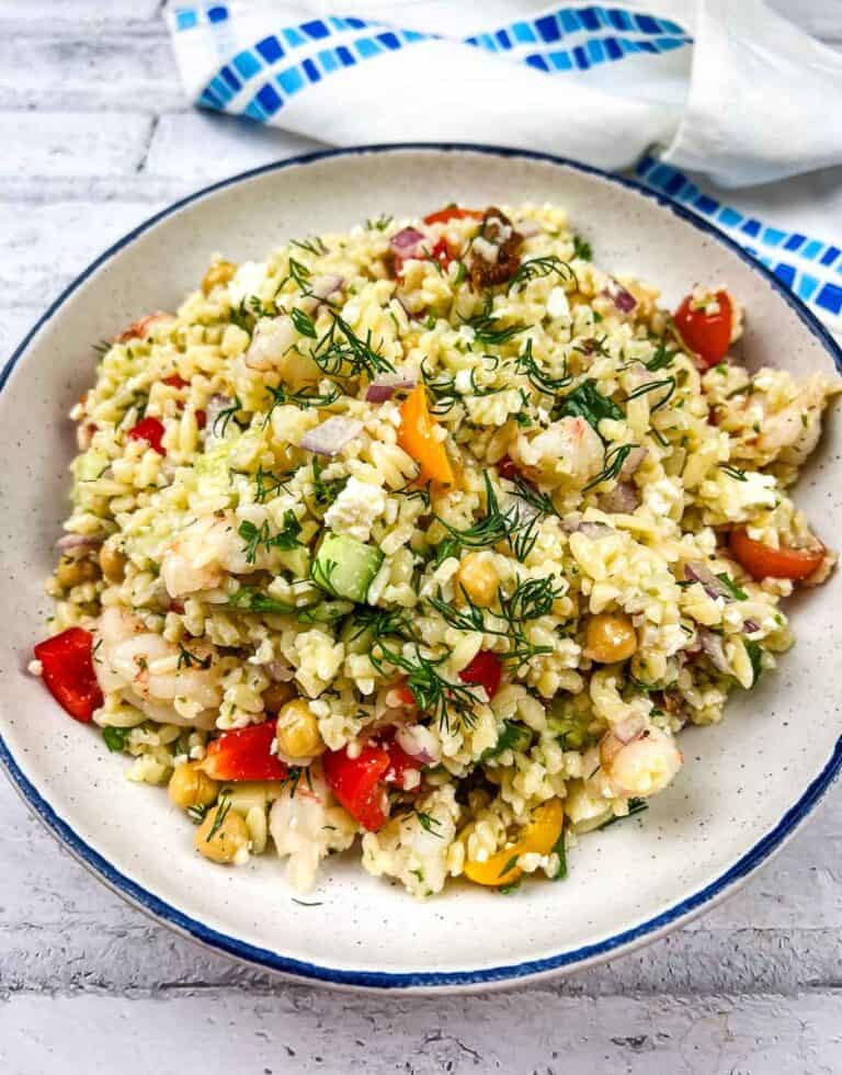 A plate of Mediterranean Orzo Salad with shrimp and vegetables.