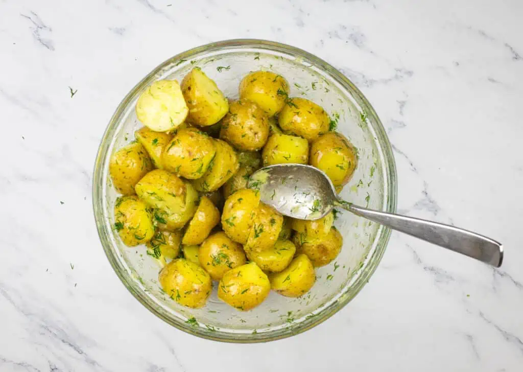 Potatoes in a glass bowl with a spoon.