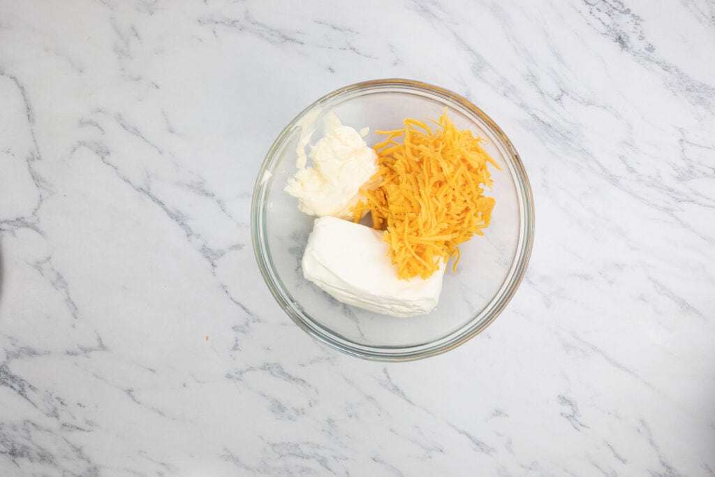 A glass bowl with cheese and cheese in it.
