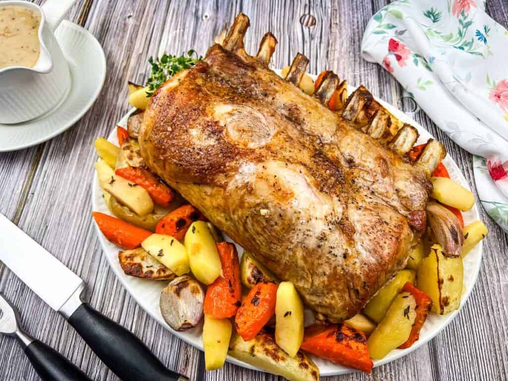 Roasted pork on a plate with carrots and potatoes.