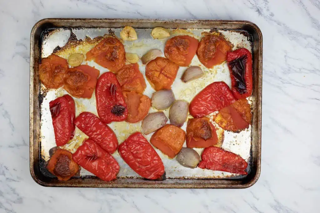 Roasted red peppers on a baking sheet.