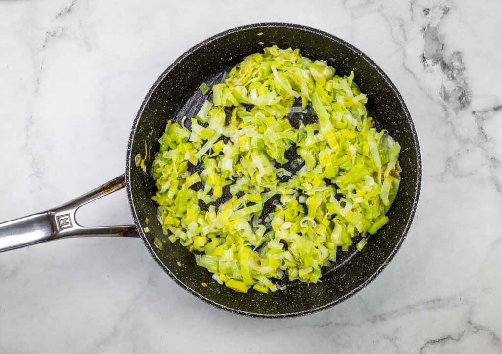 A frying pan filled with chopped leeks.