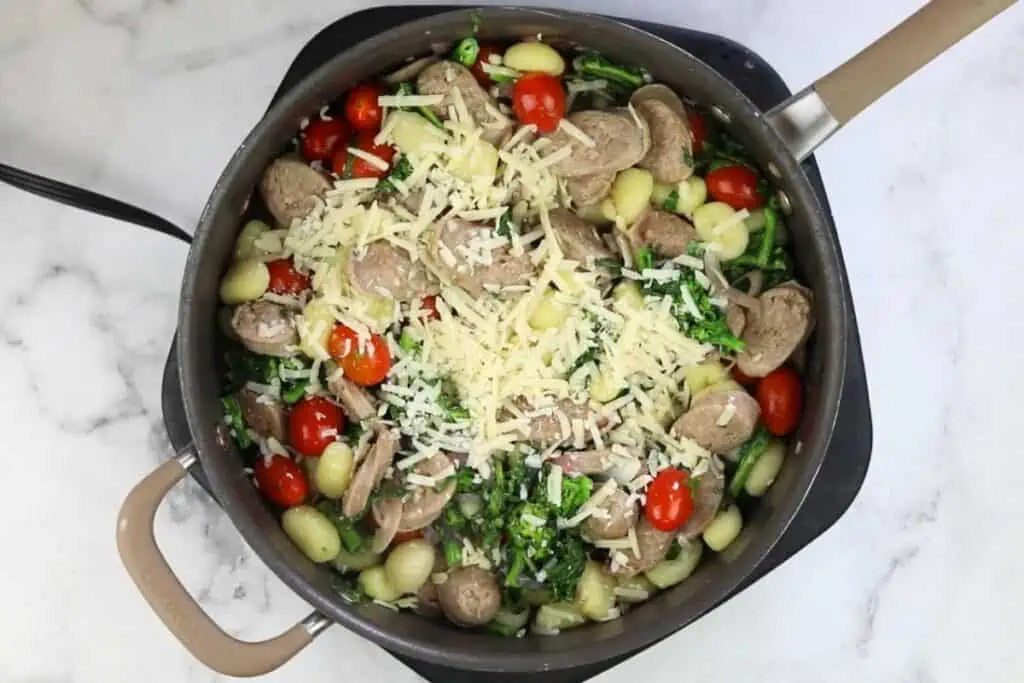 A skillet filled with vegetables and cheese.
