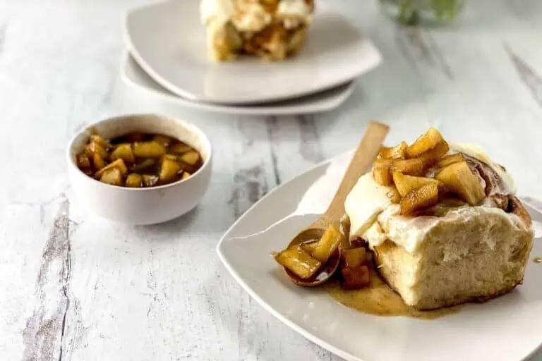 A plate with a slice of apple pie and a spoon.