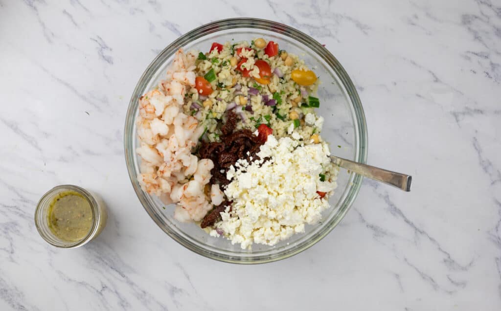 The ingredients for a greek salad are in a glass bowl.