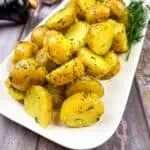 Ukrainian potatoes with dill on a white plate.