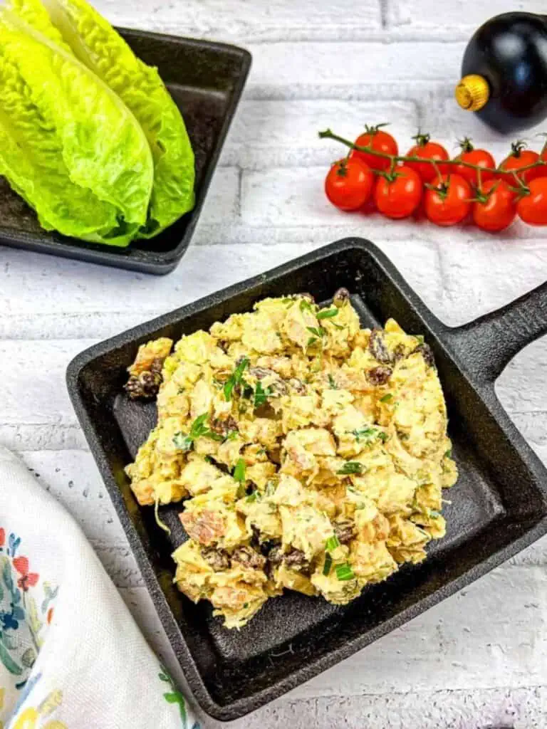 A skillet with eggs, tomatoes and lettuce on a white background.