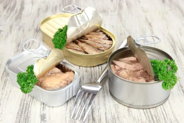 Three canned goods open on a wooden table.