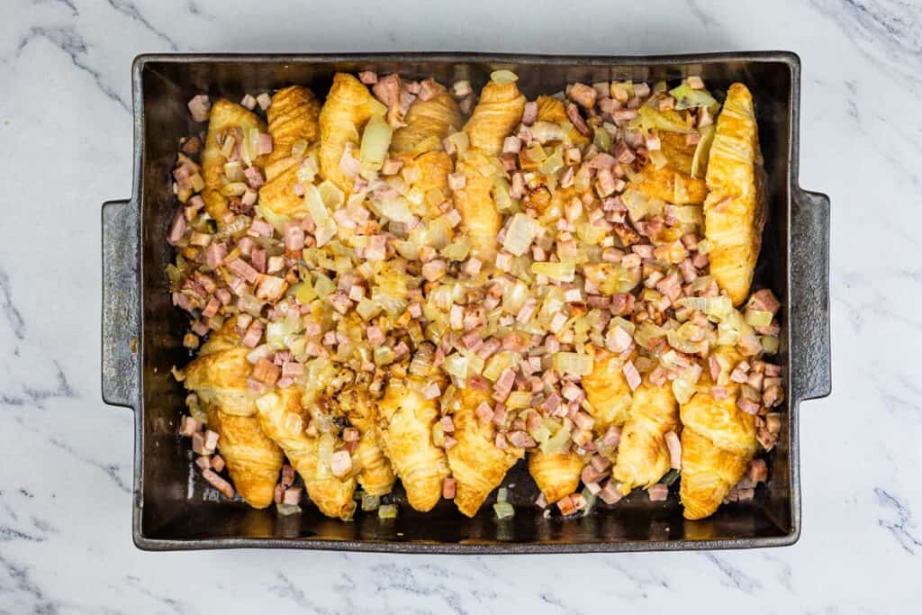 A baking pan filled with ham and onions.