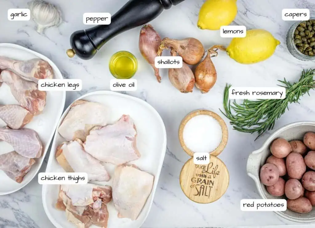 The ingredients for a chicken recipe on a white marble table.