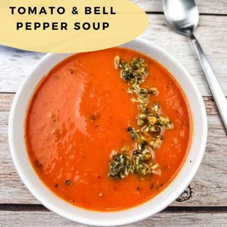 A bowl of tomato and bell pepper soup in a white bowl.