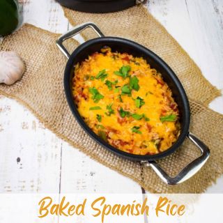 Black skillet containing baked spanish rice garnished with parsley on a rustic wooden table, with text "baked spanish rice.
