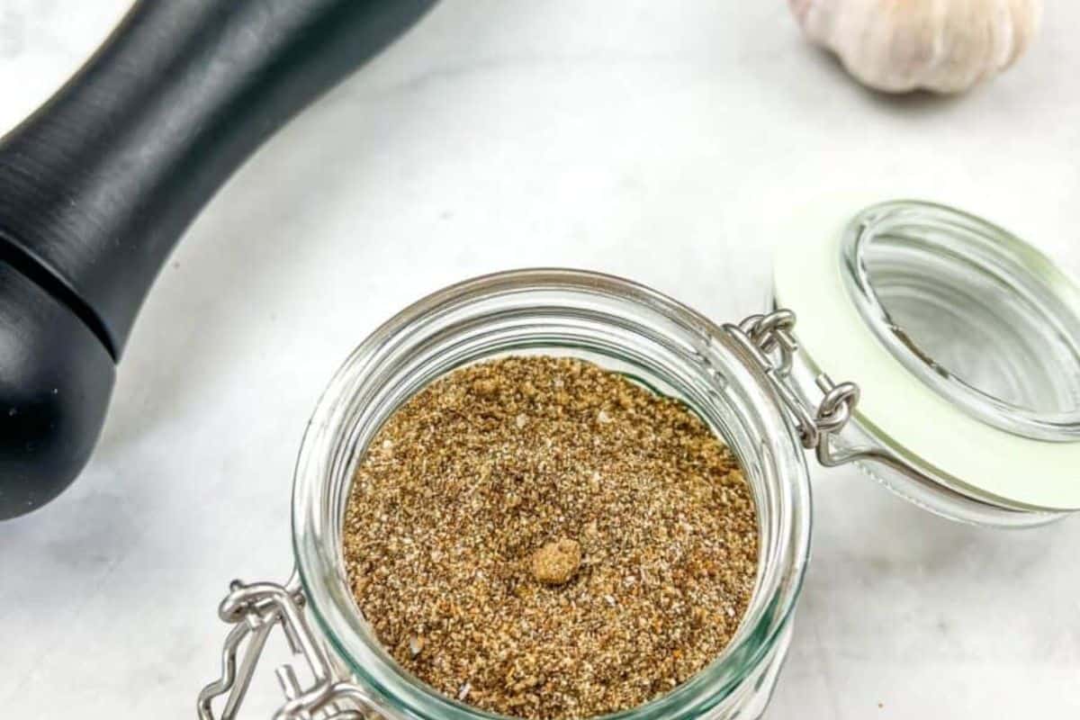 A piece of steak on a cutting board with rub on it.