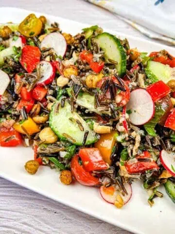 Wild rice salad served on a white rectangular plate.