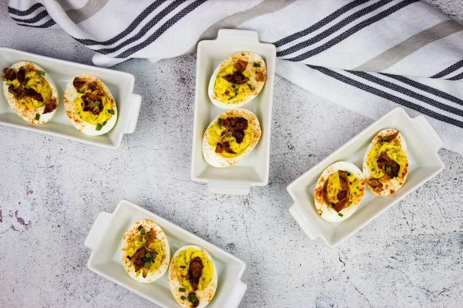 Deviled eggs on white plates.