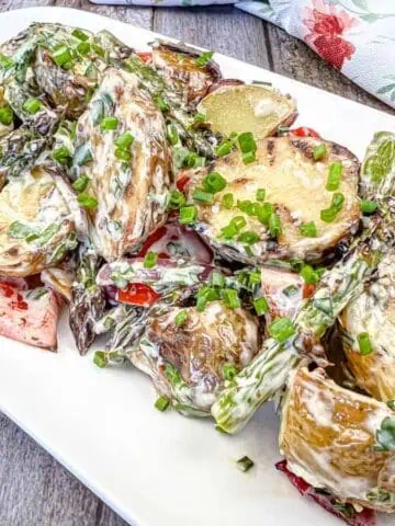 Close-up shot of Grilled Asparagus and Potato Salad on a white plate.