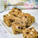 Pieces of pumpkin blondies on a white rectangular plate.